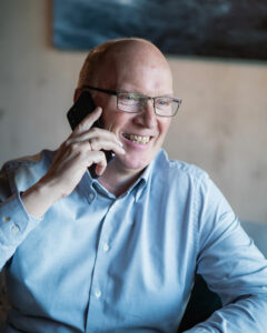 Mann i blå skjorte som prater i tlf.