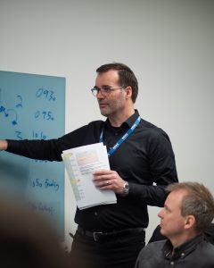 Mann i sorte klær som underviser