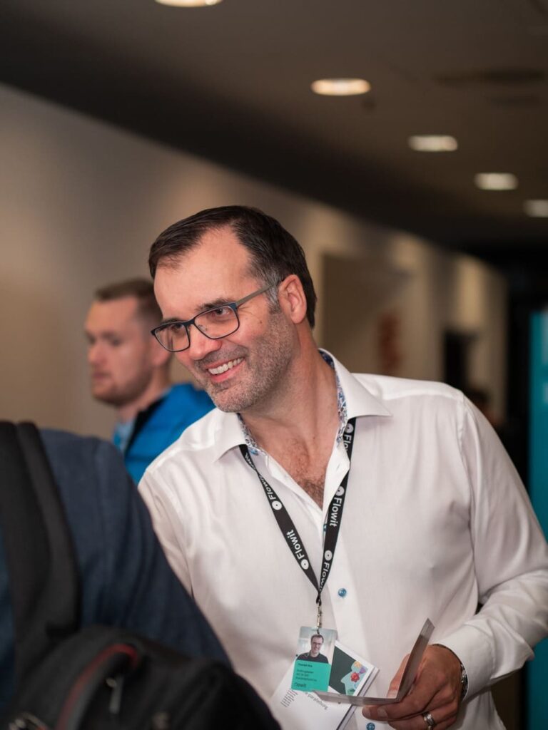 Mann i hvit skjorte som smiler.